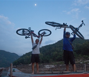 Rit and Sack unloading our bikes from the roof at Pak Beng