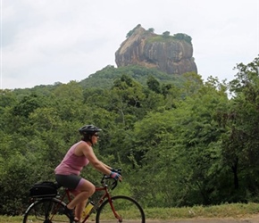 Jo Postlethwaite cycles past Sigiriya Rock Fortress