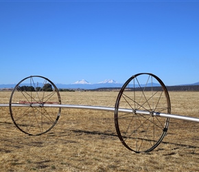 Irrigation wheels frame Sisters Mountains