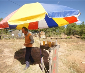 Honey seller with his tent and hives behind