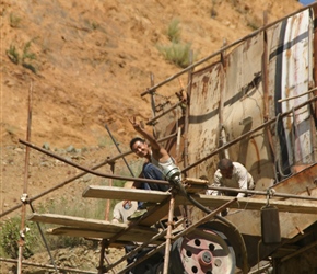 Quarry worker waves from a precarious perch
