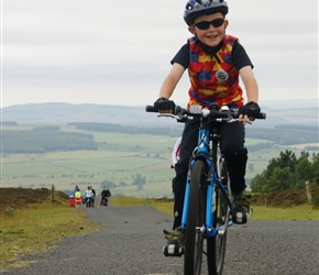 Finlay  arrives at the top of the Ros Castle climb