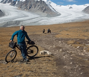Neil in front of Khüiten Peak and glacier. Note the border guards on hoses behind