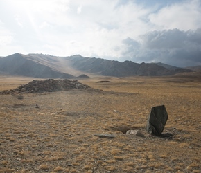 A single standing stone and a pile of rocks, probably a grave highlight an amazing dry glacial valley