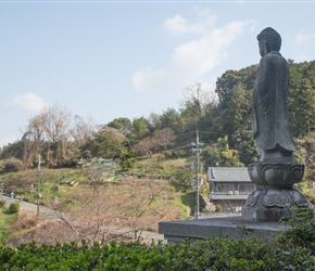 A Buddha in a cemetary overlooks the peleton approaching