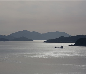 A boat sails into the snset on Omishiba Island