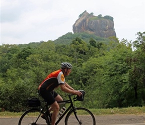 Malc Foster cycles past Sigiriya Rock Fortress