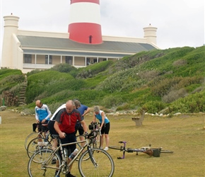 Steve remantling his bike under the shadow of the lighthouse at Cape Aguilas